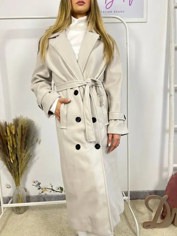 Questo cappotto doppiopetto presenta chiusura a bottoni, cintura integrata e pratiche tasche, rivelando un'eleganza raffinata e una versatilità pratica.