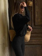 Completo da donna con top asimmetrico a tinta unita e pantaloni a zampa, top casual a maniche lunghe con spalle scese e pantaloni, abbigliamento da donna autunno e inverno per l'uso quotidiano