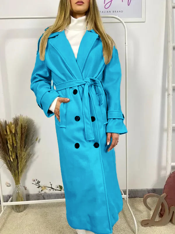 Questo cappotto doppiopetto presenta chiusura a bottoni, cintura integrata e pratiche tasche, rivelando un'eleganza raffinata e una versatilità pratica.