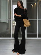 Completo da donna con top asimmetrico a tinta unita e pantaloni a zampa, top casual a maniche lunghe con spalle scese e pantaloni, abbigliamento da donna autunno e inverno per l'uso quotidiano