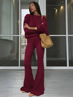 Completo da donna con top asimmetrico a tinta unita e pantaloni a zampa, top casual a maniche lunghe con spalle scese e pantaloni, abbigliamento da donna autunno e inverno per l'uso quotidiano