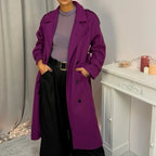 Questo cappotto doppiopetto presenta chiusura a bottoni, cintura integrata e pratiche tasche, rivelando un'eleganza raffinata e una versatilità pratica.