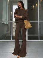 Completo da donna con top asimmetrico a tinta unita e pantaloni a zampa, top casual a maniche lunghe con spalle scese e pantaloni, abbigliamento da donna autunno e inverno per l'uso quotidiano