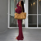 Completo da donna con top asimmetrico a tinta unita e pantaloni a zampa, top casual a maniche lunghe con spalle scese e pantaloni, abbigliamento da donna autunno e inverno per l'uso quotidiano